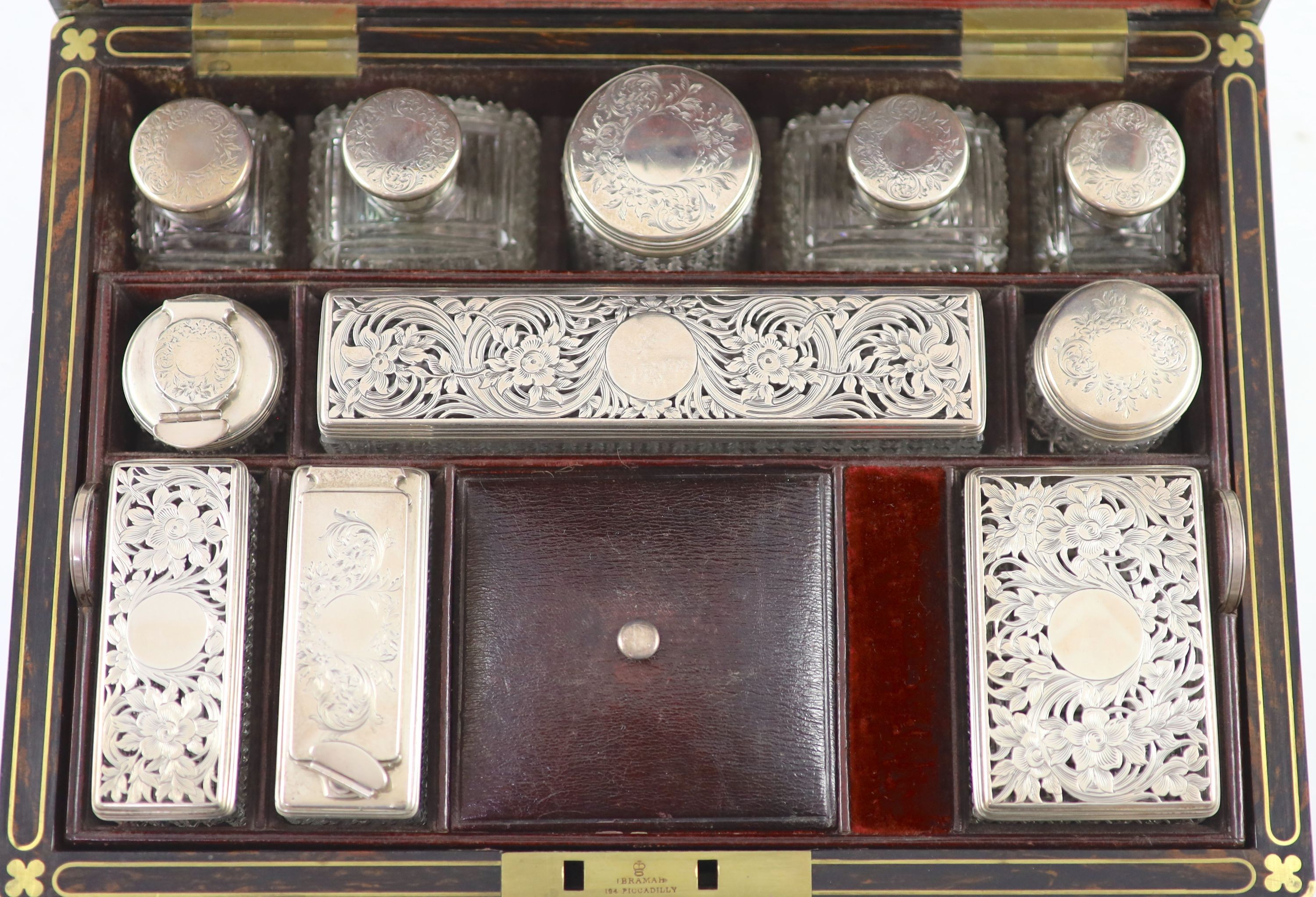 A good late William IV brass inlaid two handled coromandel wood travelling toilet set, containing eleven silver mounted glass jars etc.